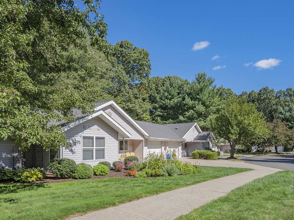 A suburban house with well-maintained landscaping under a clear blue sky.