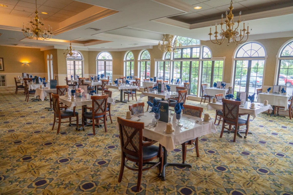 An elegant dining room with neatly arranged tables and large windows.