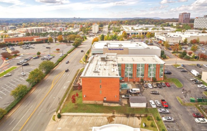 Aerial view of an urban area with roads, buildings, and a parking lot.