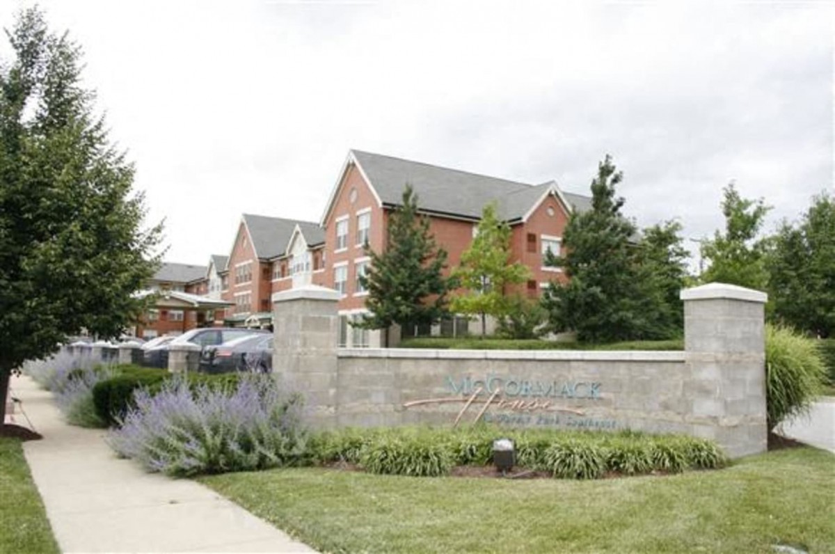 A scenic view of a residential building surrounded by trees and landscaping.
