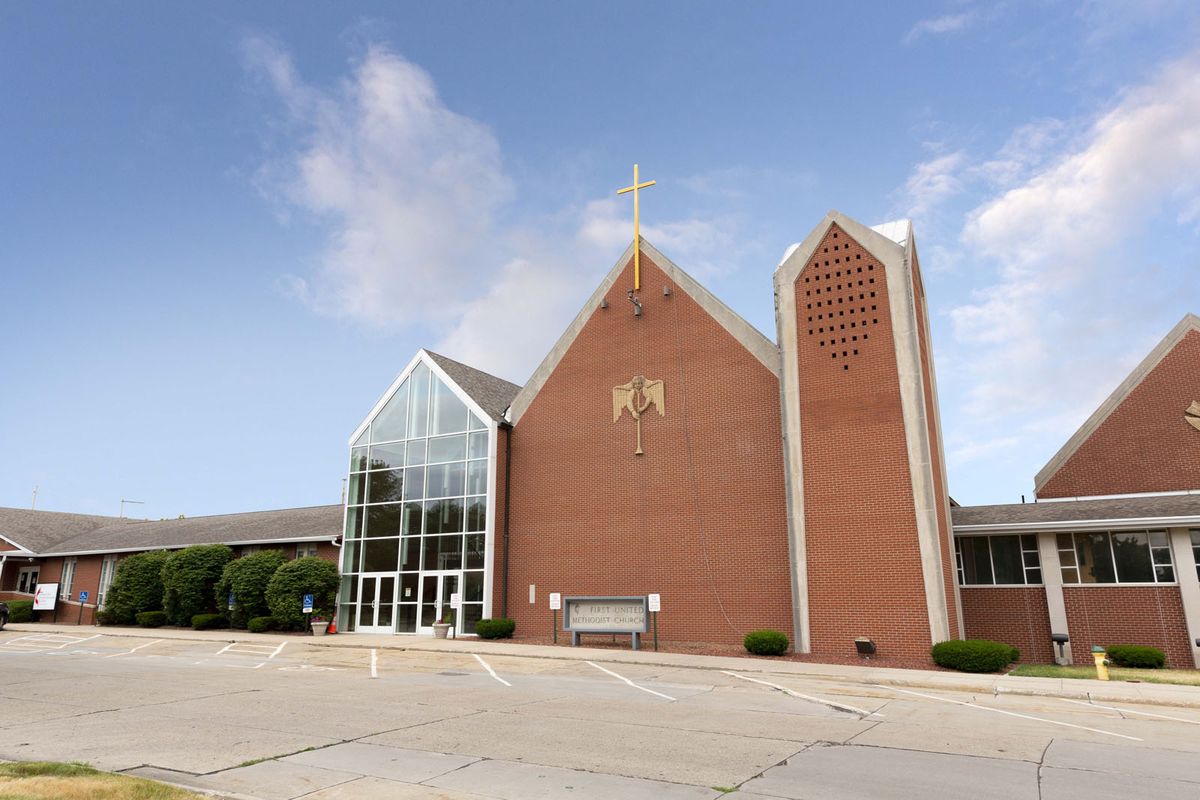 A modern brick church with a prominent cross and glass entrance.