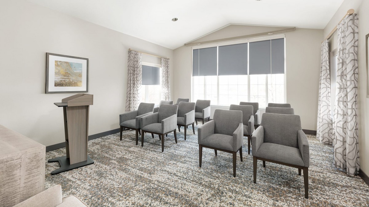 A small conference room with a podium and rows of chairs facing forward.