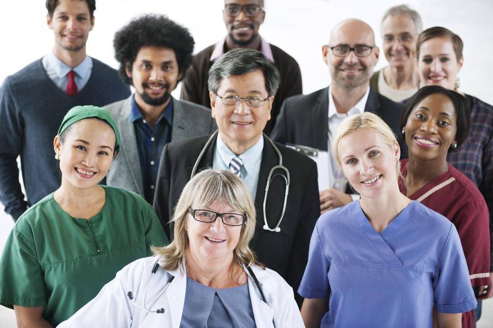 A diverse group of healthcare professionals posing together, showcasing teamwork and unity in the medical field.