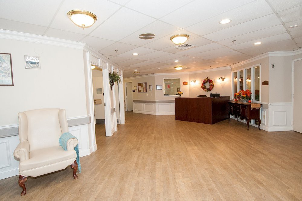 A bright and spacious lobby area with a reception desk, comfortable seating, and elegant lighting.