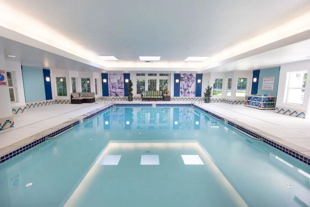A luxurious indoor swimming pool with modern design elements and ample natural light.