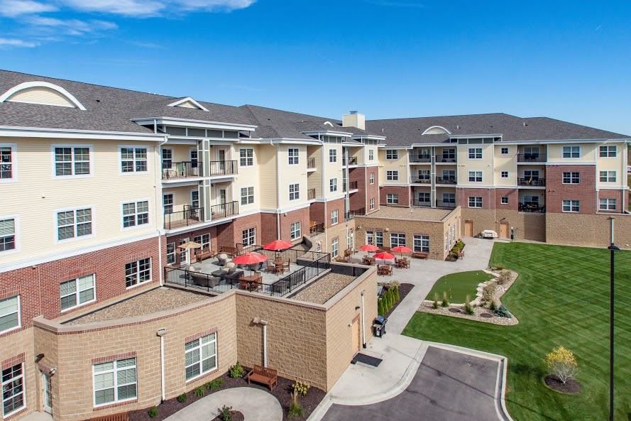 A modern apartment complex with a landscaped courtyard and outdoor seating.