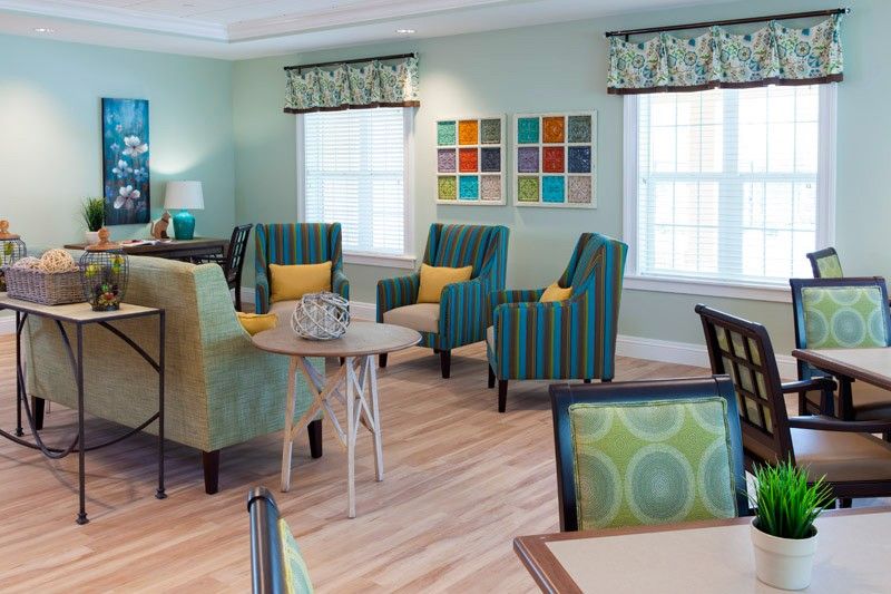 A cozy living room with vibrant seating and abstract wall art.