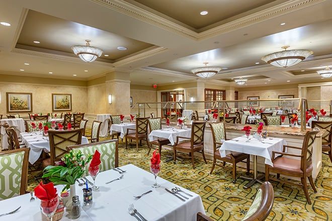 An elegantly decorated restaurant dining room with neatly arranged tables and chairs.