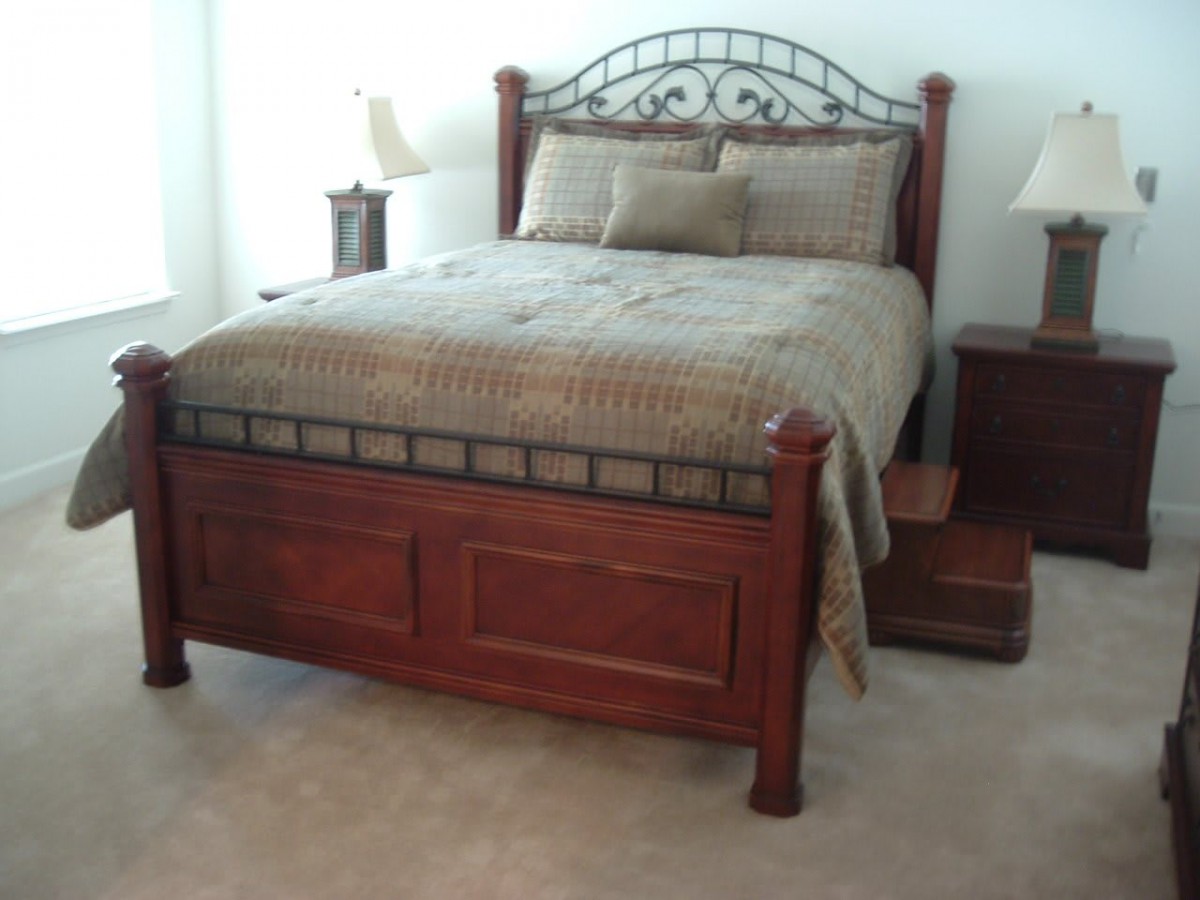 A well-furnished bedroom with a wooden bed and matching side tables.
