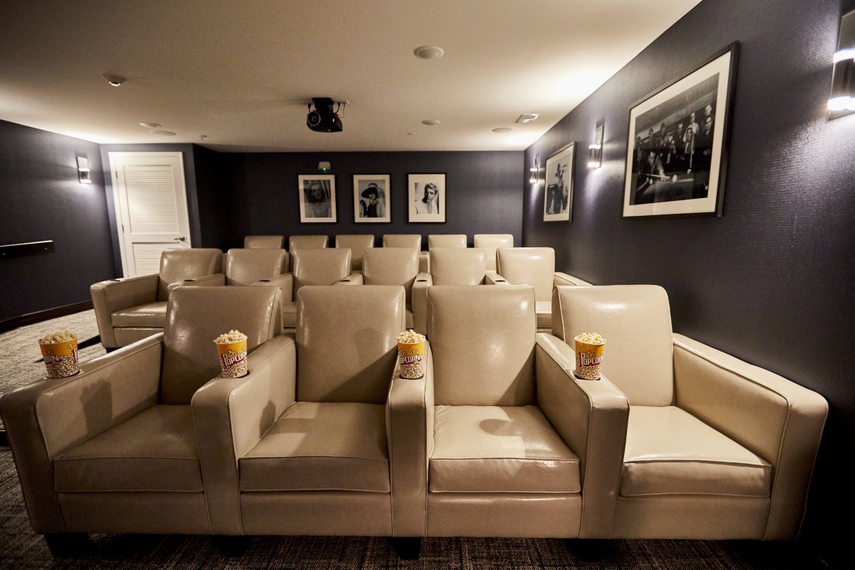 A luxurious home theater with leather seating and popcorn ready for a movie night.