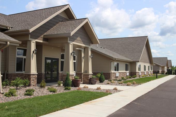 A modern residential building with well-maintained landscaping and a sidewalk.
