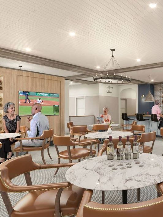 A modern restaurant bar with people dining and a television on the wall.