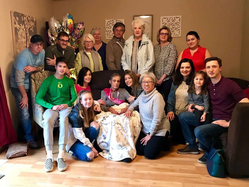 A multigenerational family gathering captured in an indoor group photo.