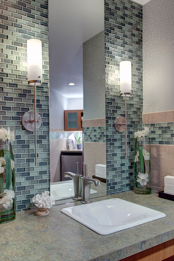 A modern bathroom featuring stylish tile work, elegant lighting fixtures, and tasteful decor.