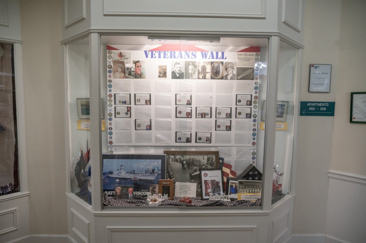 A display case showcasing the Veteran Wall with historical memorabilia and military exhibits.