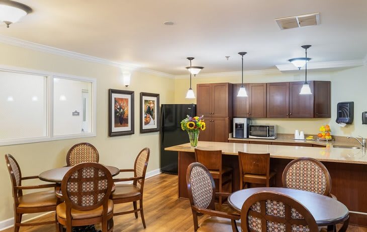 A cozy kitchen and dining area with warm lighting and wooden furniture.