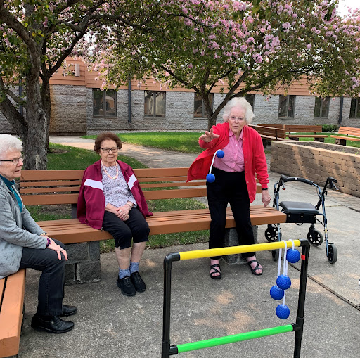 Seniors enjoying a sunny day at the park, participating in a fun outdoor game.