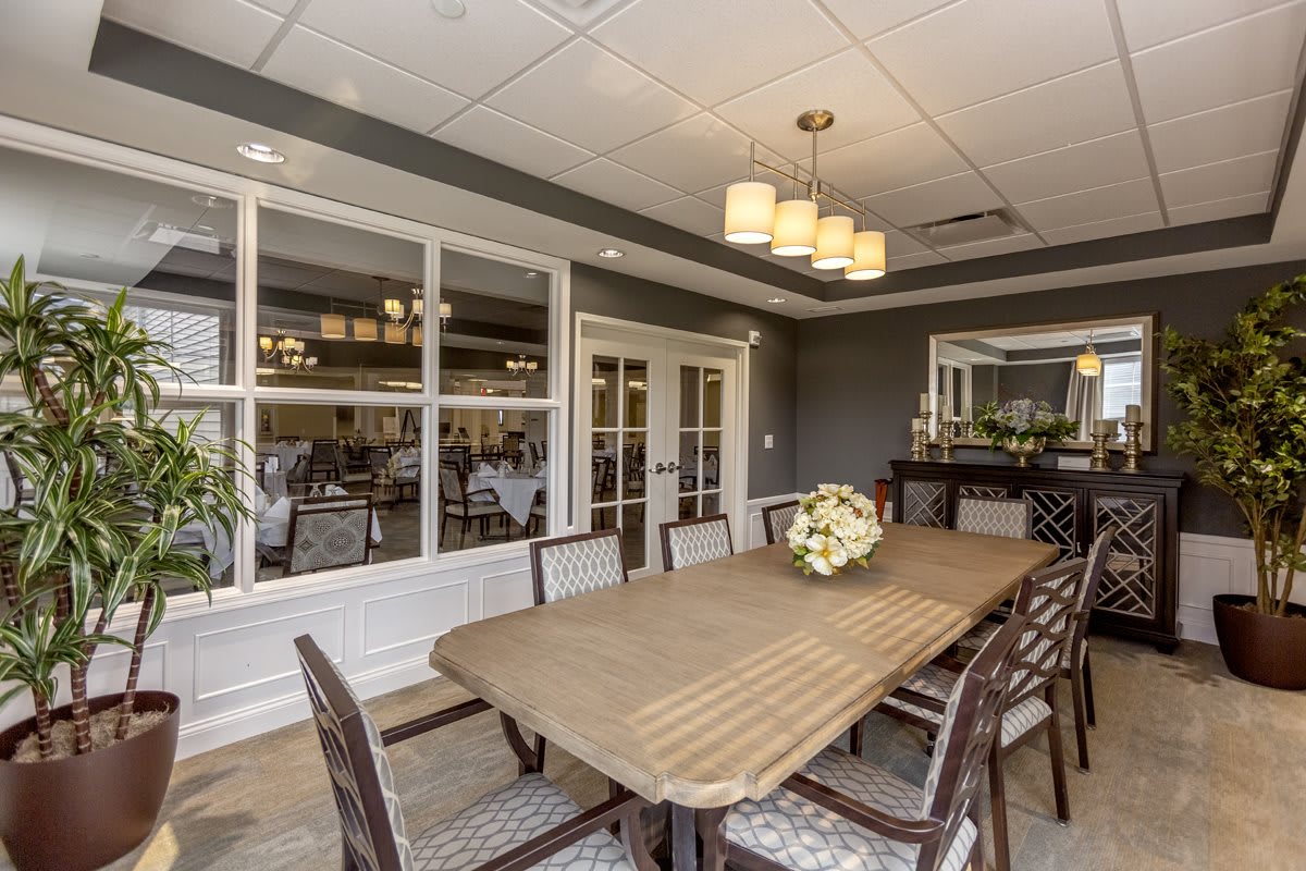 A well-decorated dining room featuring a large table, chairs, and elegant lighting.