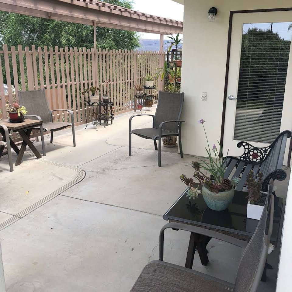 A cozy patio area with seating and potted plants.