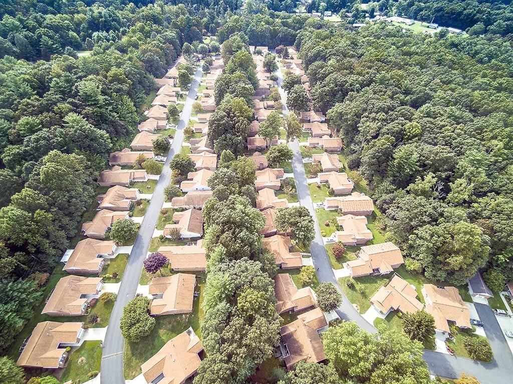 An aerial view of a suburban housing development surrounded by trees.