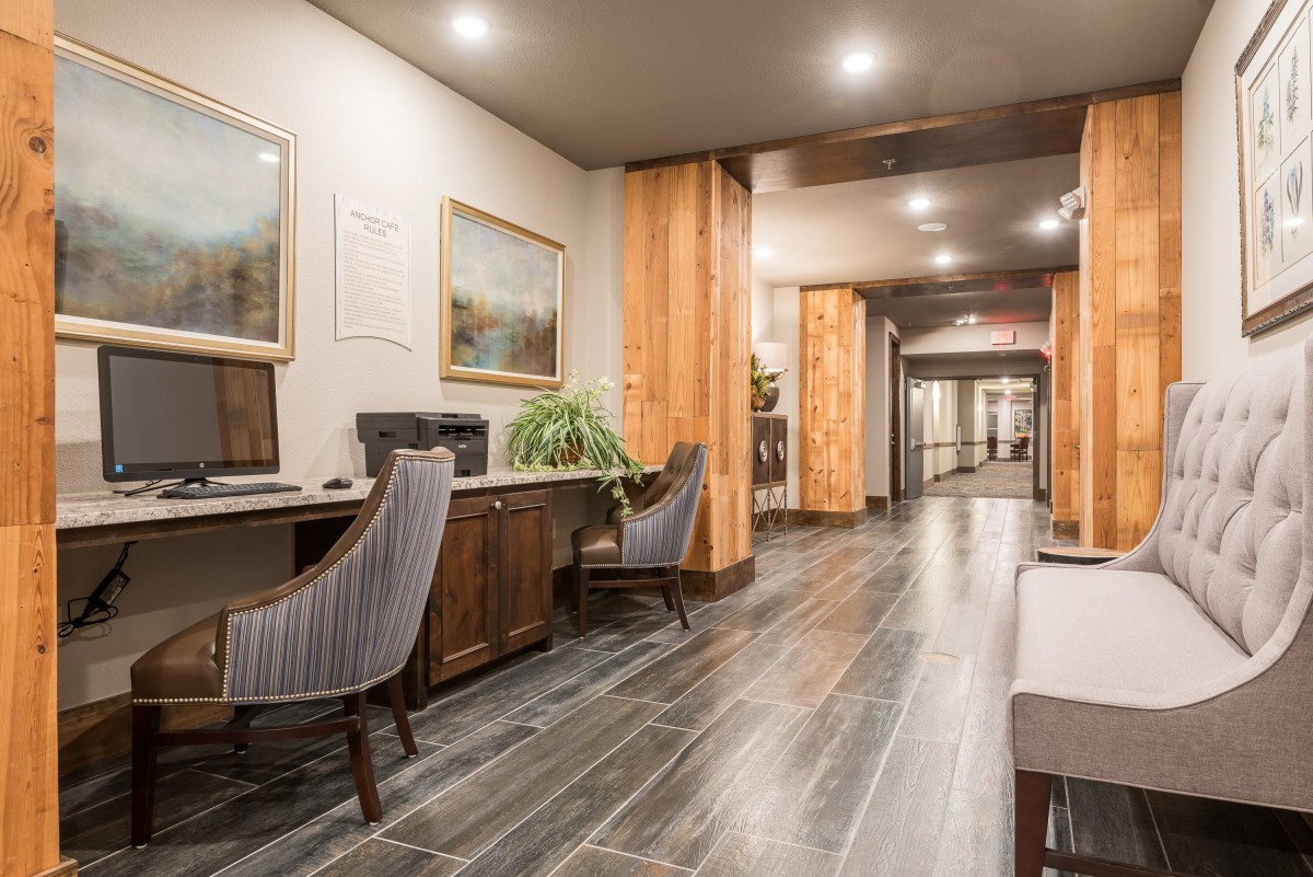 A modern office space with wood accents, featuring computer desks and comfortable chairs.