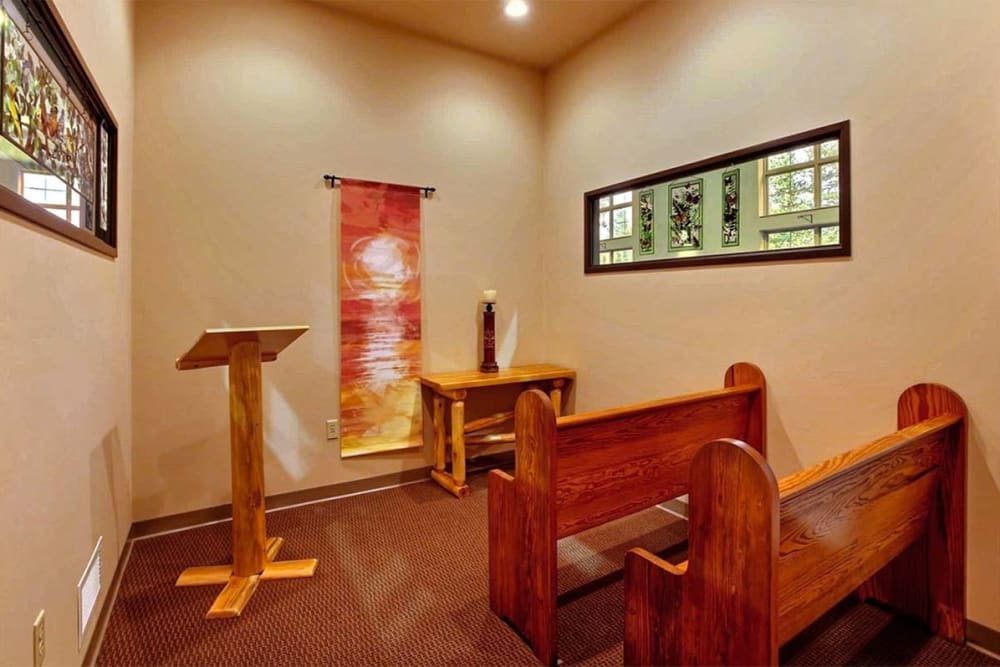 A small chapel interior with wooden pews and a podium.
