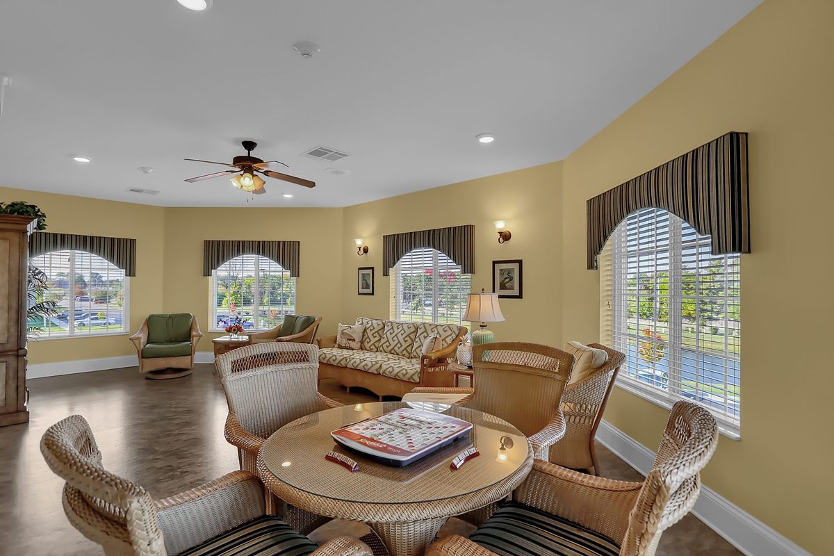A cozy living room featuring a seating area with comfortable chairs and large windows.