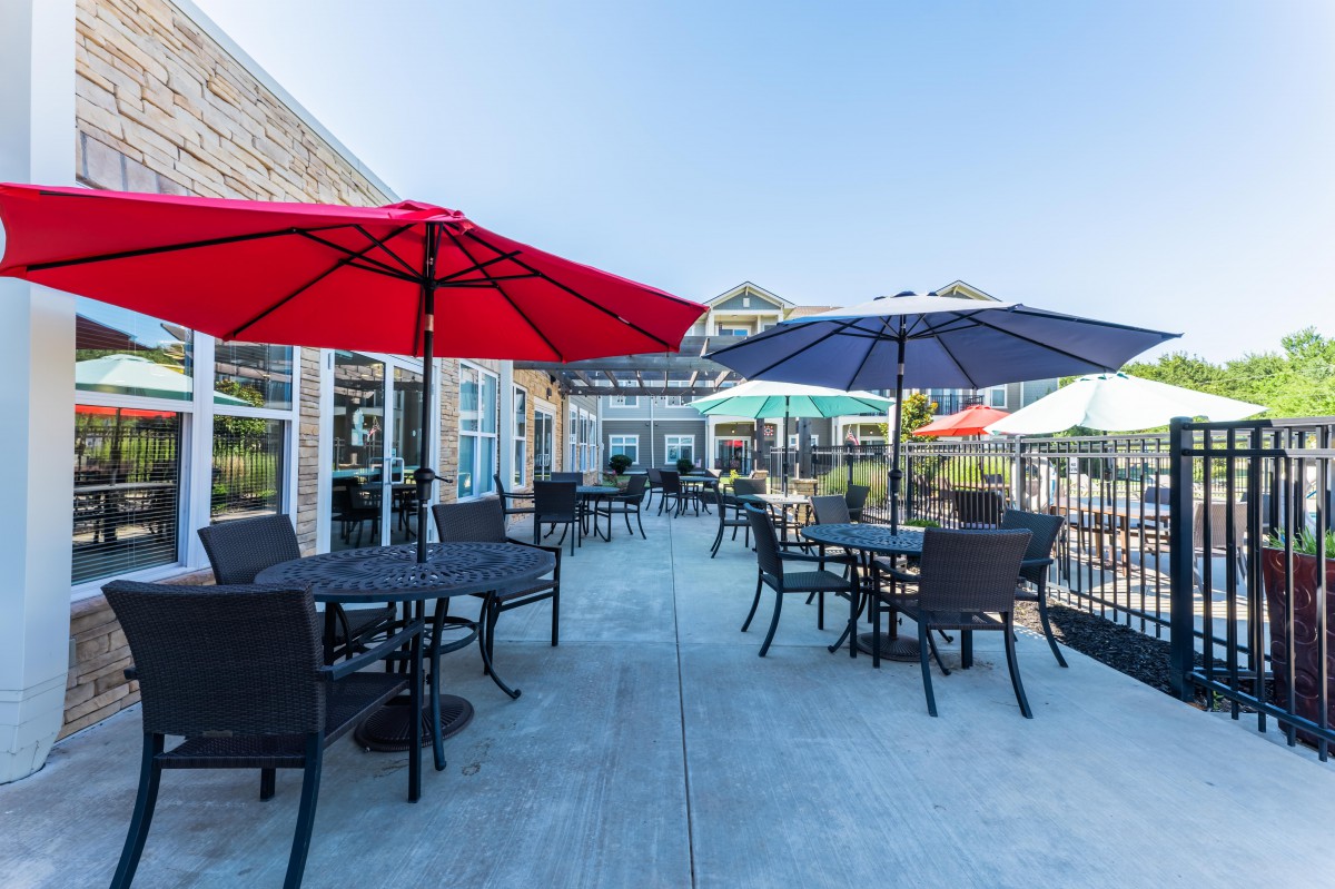 An outdoor patio with tables and umbrellas, providing seating for a restaurant or caf.