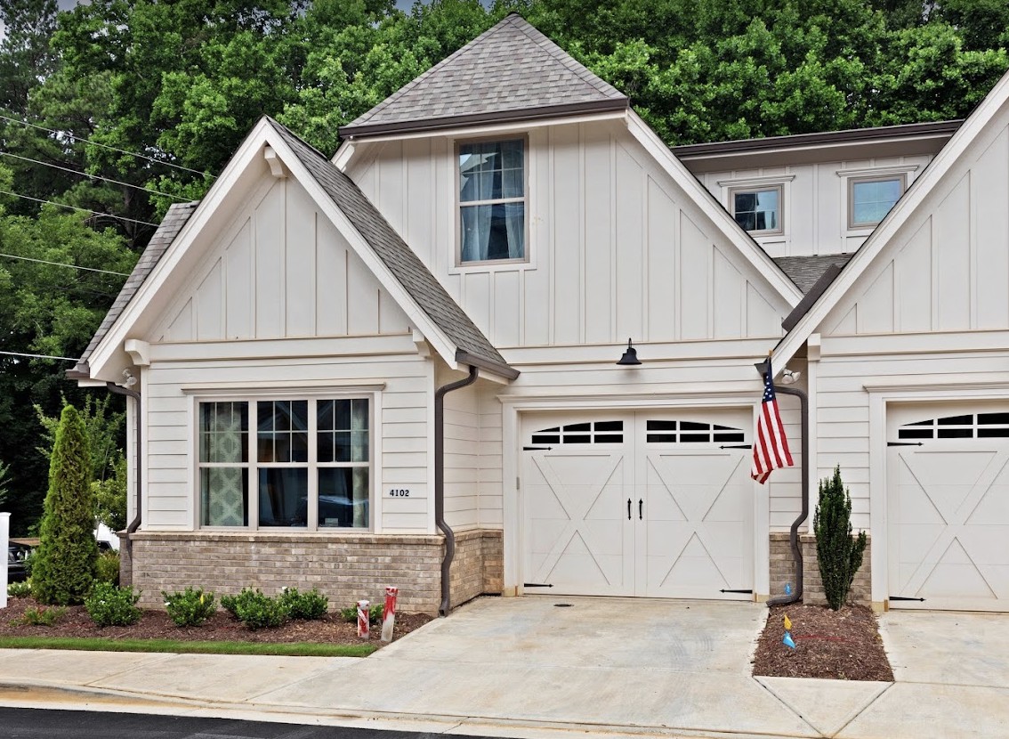 A charming suburban house with a garage and an American flag.