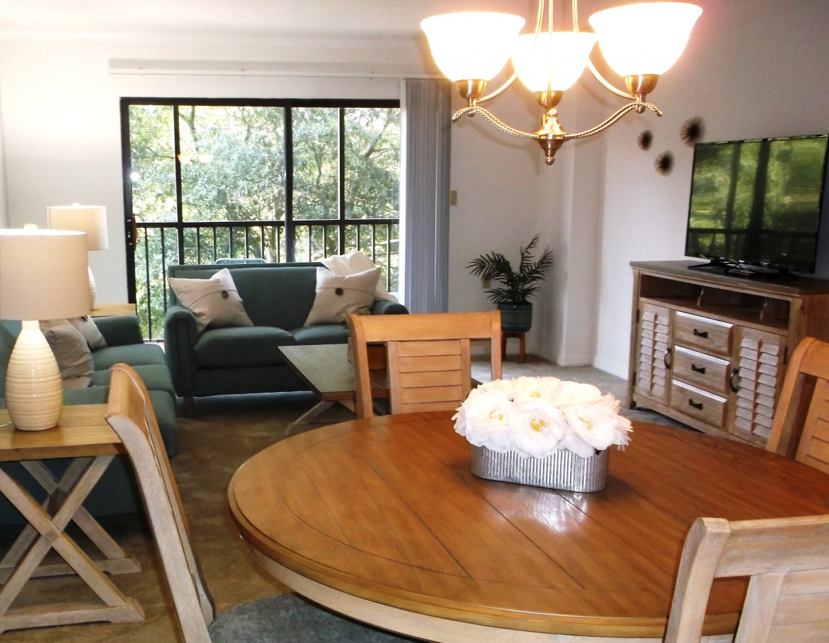 A cozy living room and dining area with wooden furniture and elegant lighting.