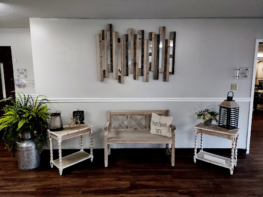 A cozy living room setup featuring a wooden bench, decorative tables, and wall art.