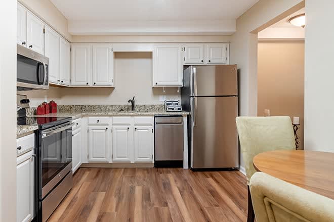 Modern kitchen with stainless steel appliances and white cabinetry.