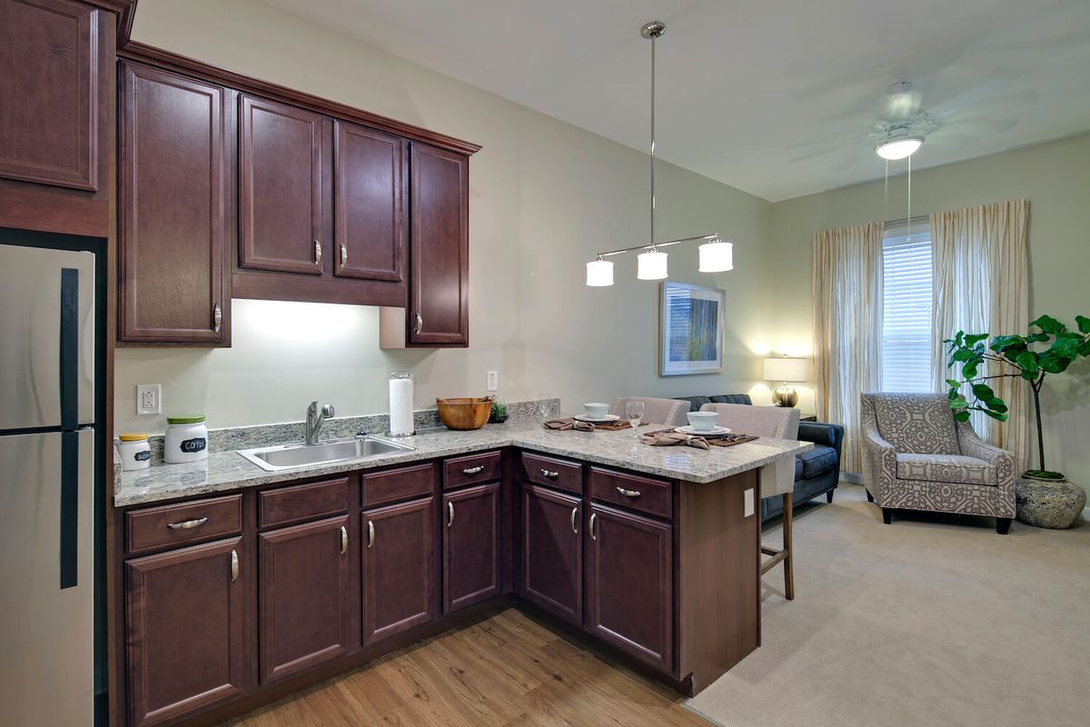 Modern kitchen with dark wood cabinetry and a connected dining area.