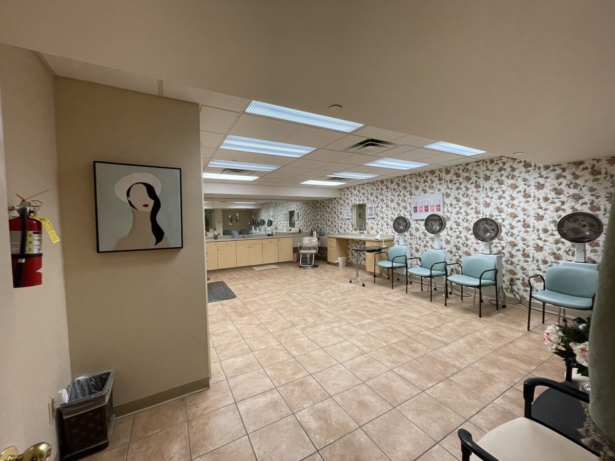 A clean and modern waiting room with floral wallpaper and seating arrangements.