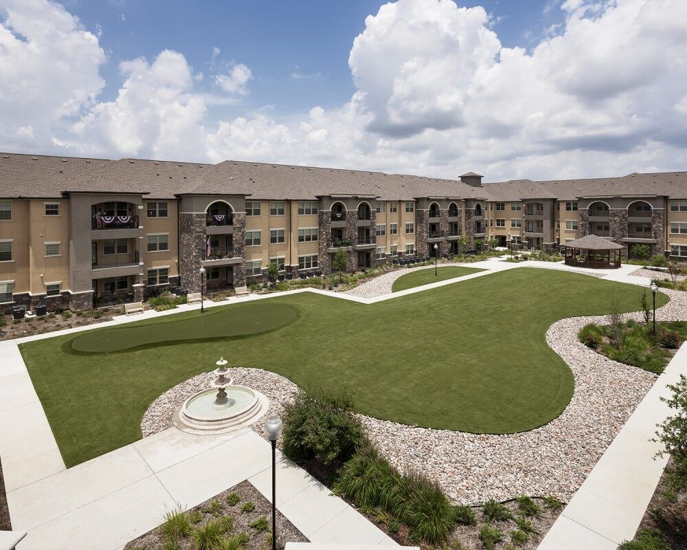 A view of a well-maintained apartment complex with landscaped gardens and walkways.