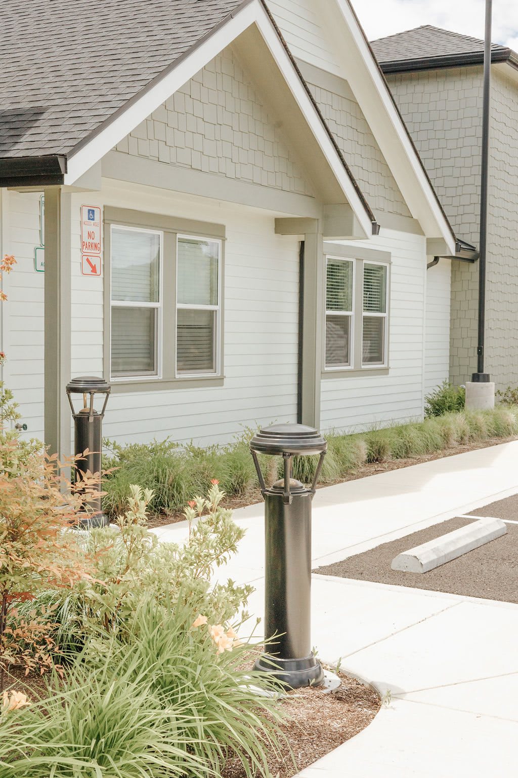 A small residential house with a well-maintained walkway and garden lighting.