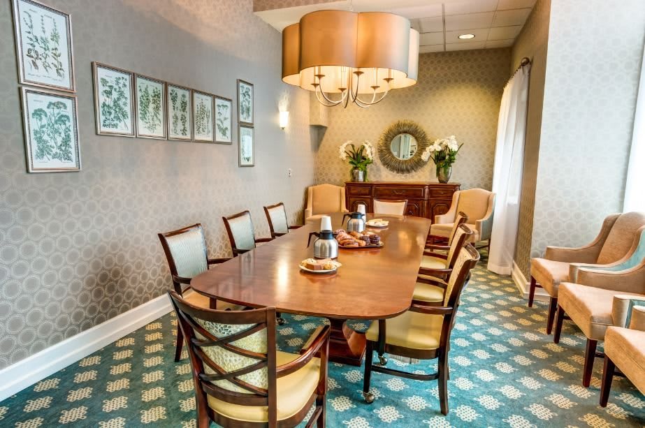 A stylish dining room featuring a wooden table, chairs, and elegant lighting.