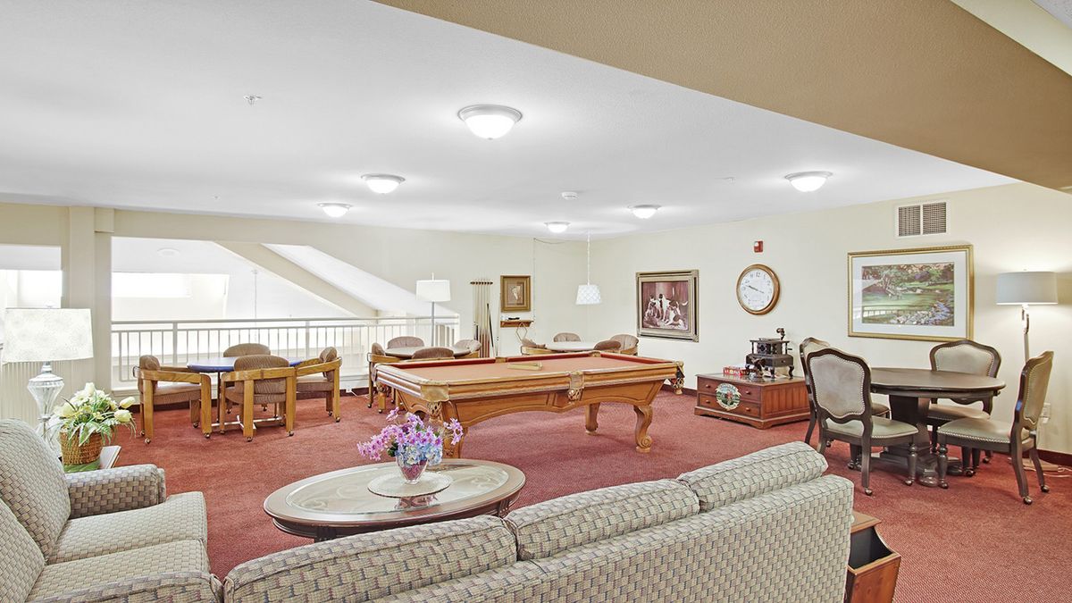 A cozy game room featuring a billiards table, comfortable seating, and tasteful decor.