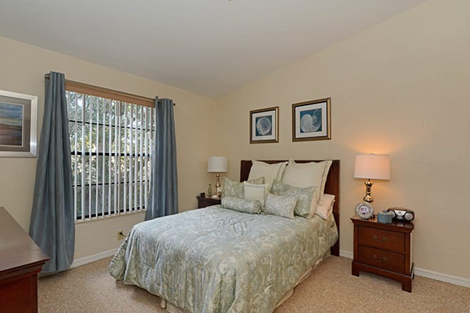 A cozy bedroom with a bed, side tables, and soft lighting.