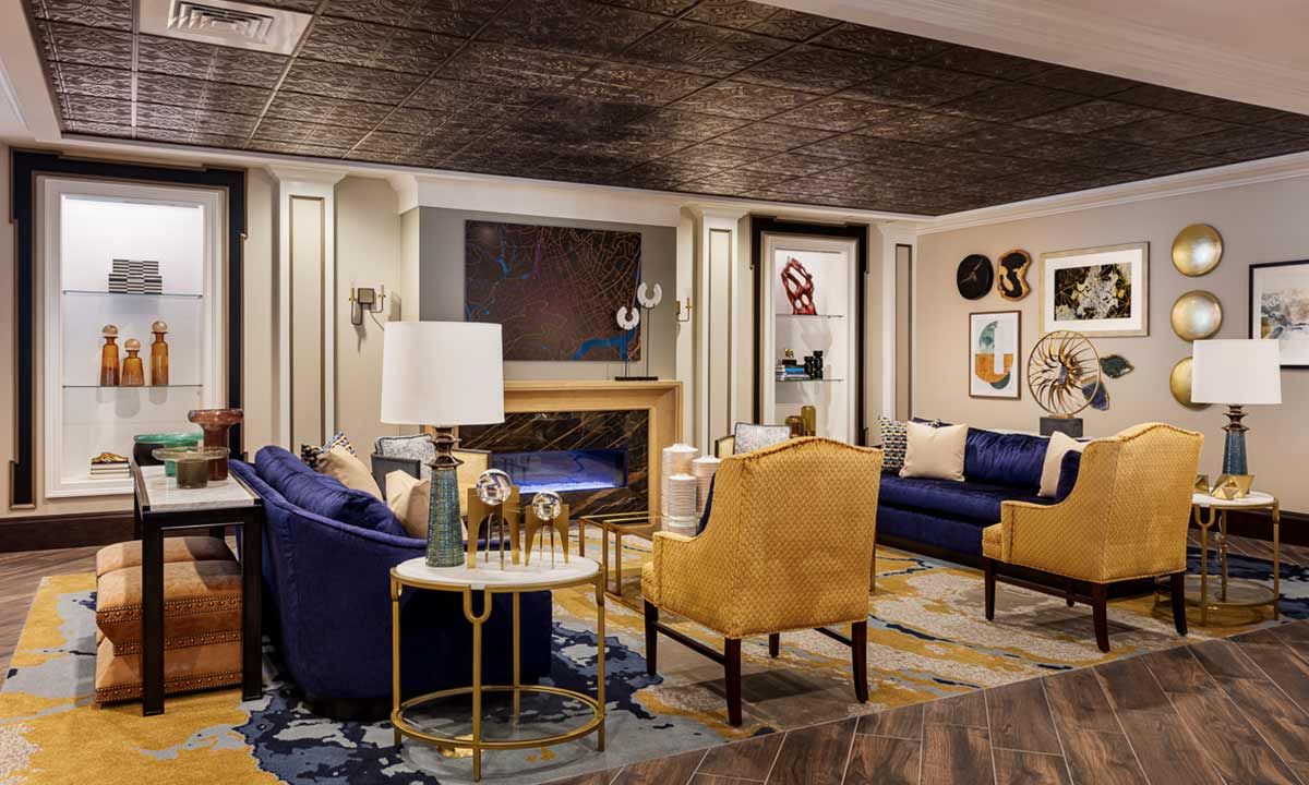 A stylishly decorated living room featuring a mix of blue and yellow furniture with contemporary wall art.