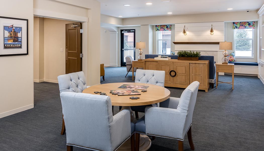 A modern living room with a round table and upholstered chairs.