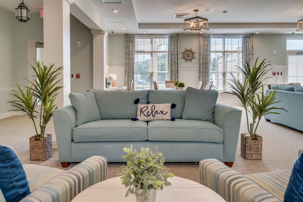 A cozy and stylish living room featuring a light blue sofa, accent pillows, and plenty of natural light.