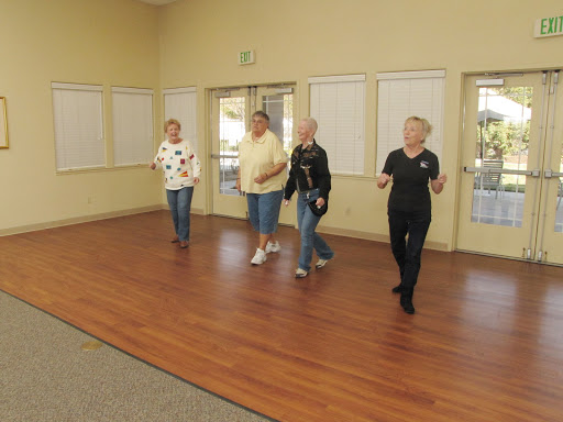 A group of older adults enjoying a dance session together indoors.