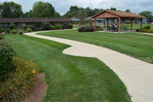 A scenic view of a landscaped park with a winding pathway and gazebo.