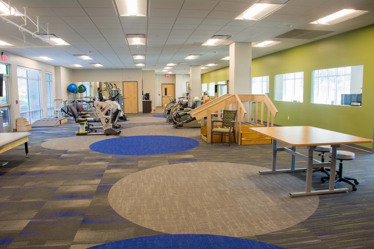 A modern fitness center with various exercise equipment and a spacious layout.