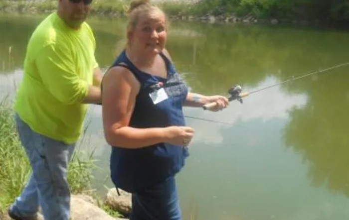 Two people enjoying fishing by a lake.