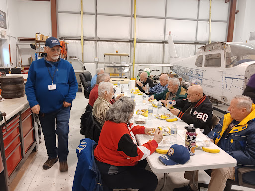 A group of individuals enjoying a meal together in a warehouse setting.