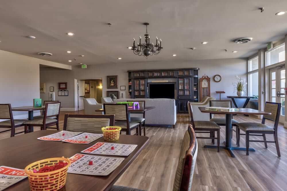 A cozy recreation room in a retirement home with tables set up for bingo.