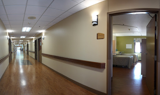 A view of a hospital corridor leading to patient rooms.