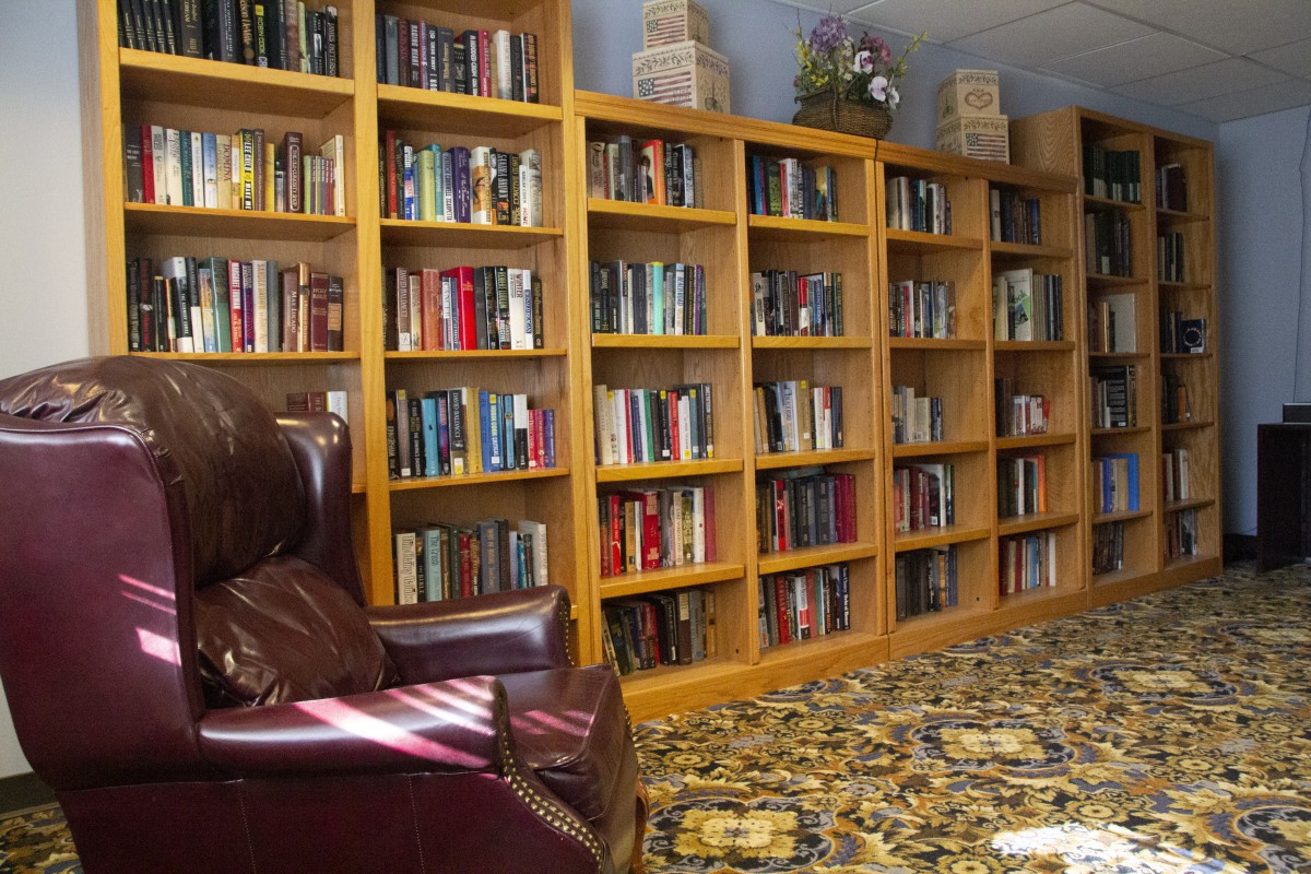A cozy library corner with bookshelves filled with books and a comfortable armchair.